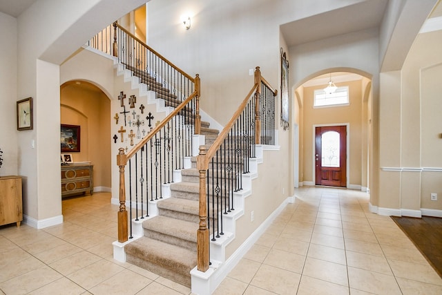 foyer with a towering ceiling and light tile patterned flooring