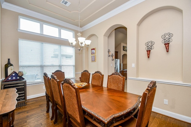 dining room with a chandelier, dark wood-type flooring, and ornamental molding