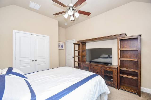 bedroom with ceiling fan, a closet, light colored carpet, and vaulted ceiling