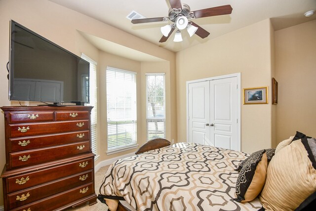 bedroom featuring light carpet, a closet, and ceiling fan