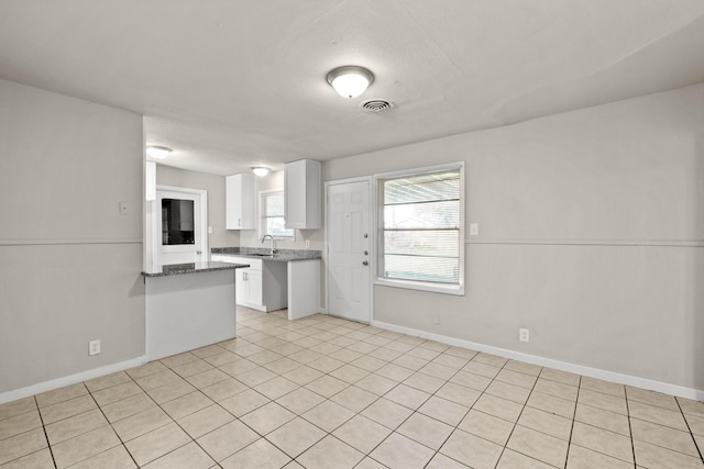 kitchen featuring light tile patterned flooring, white cabinetry, and sink