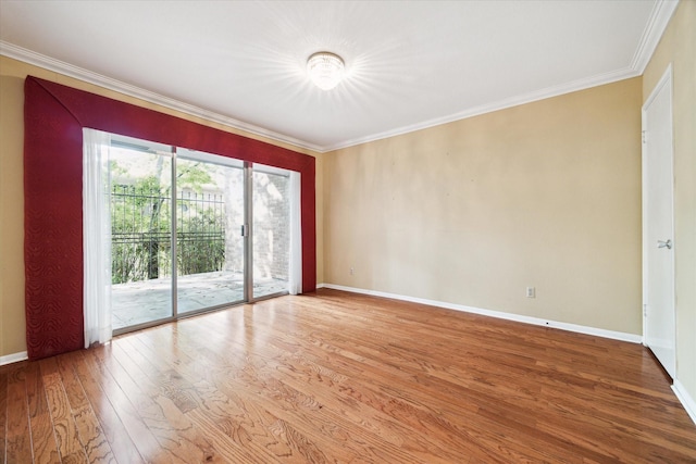 spare room featuring hardwood / wood-style floors and crown molding