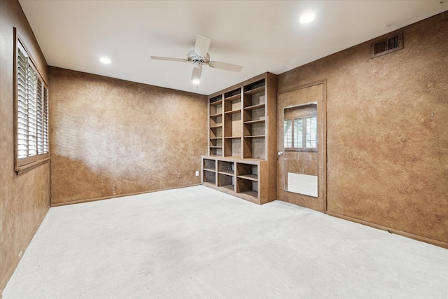 unfurnished living room with ceiling fan, built in features, and carpet floors