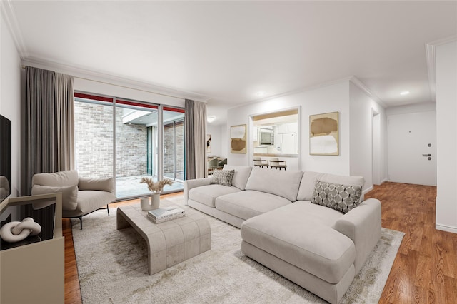 living area with recessed lighting, ornamental molding, baseboards, and wood finished floors