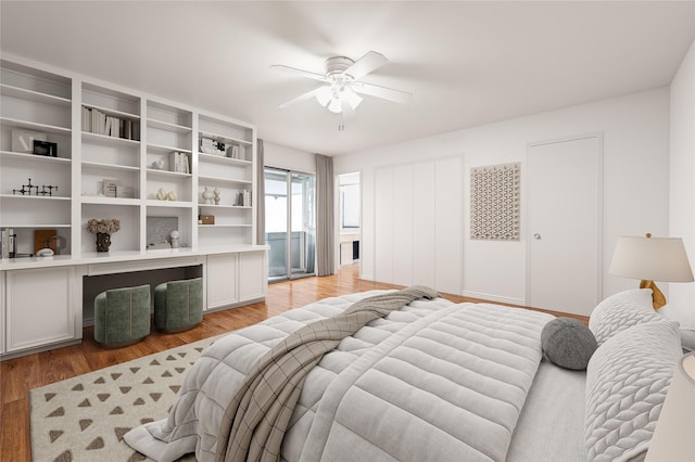 bedroom featuring light wood-type flooring, a ceiling fan, and built in study area