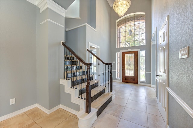 tiled foyer featuring a notable chandelier and a high ceiling