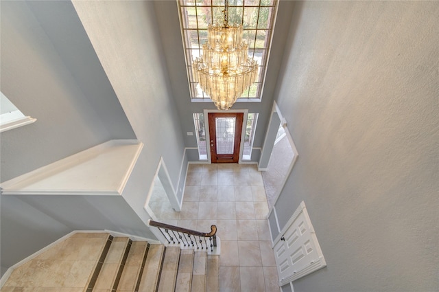 tiled foyer featuring an inviting chandelier