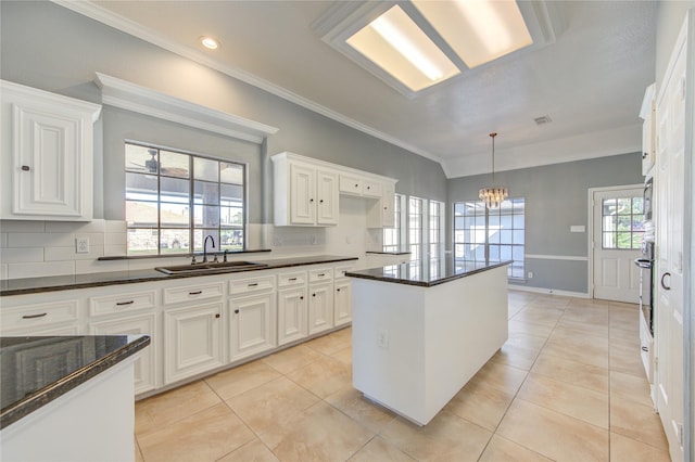 kitchen featuring backsplash, sink, white cabinets, and a healthy amount of sunlight