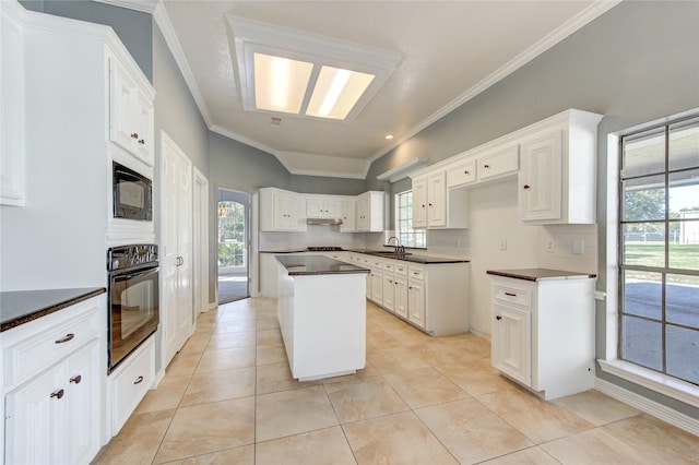 kitchen with a center island, black appliances, white cabinets, crown molding, and tasteful backsplash