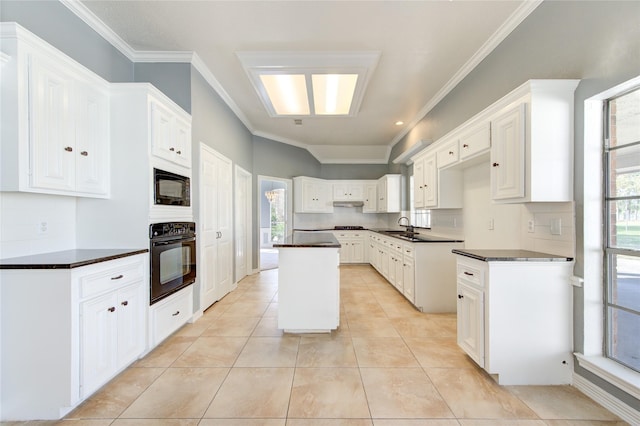 kitchen with decorative backsplash, crown molding, black appliances, white cabinets, and a kitchen island