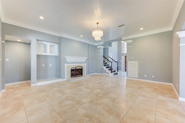 unfurnished living room with a tile fireplace, an inviting chandelier, crown molding, light tile patterned floors, and decorative columns