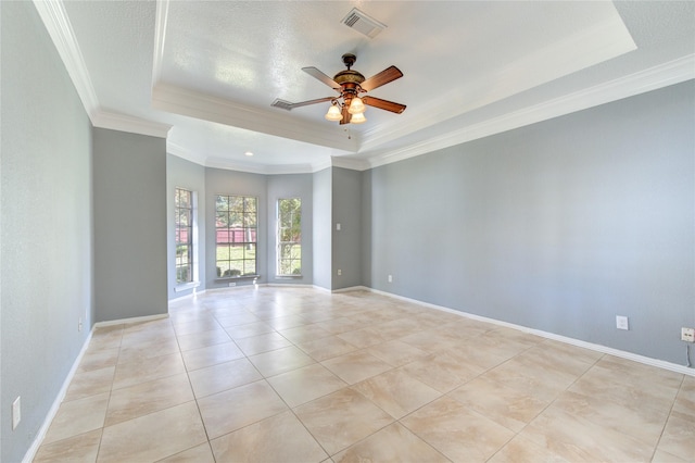 tiled spare room featuring ceiling fan, ornamental molding, and a tray ceiling