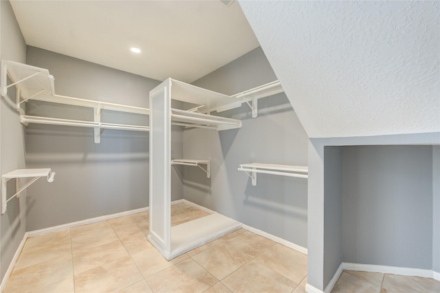 spacious closet with light tile patterned floors