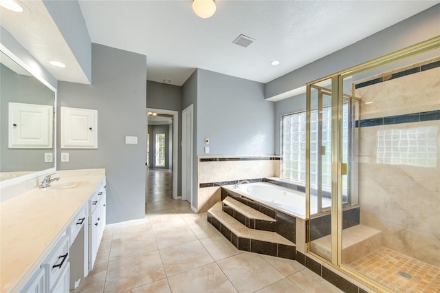 bathroom with tile patterned flooring, vanity, a textured ceiling, and independent shower and bath