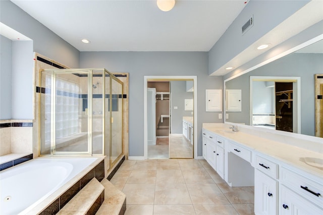 bathroom featuring plus walk in shower, vanity, and tile patterned flooring