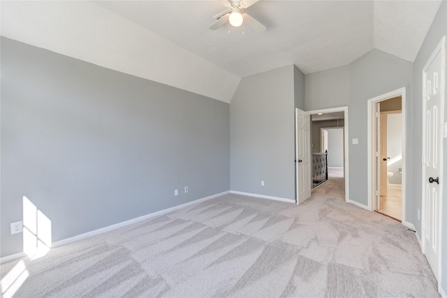 unfurnished bedroom with ceiling fan, light colored carpet, and lofted ceiling