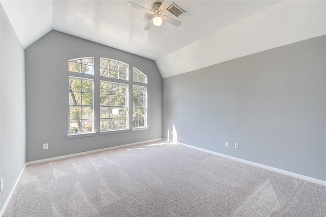 carpeted spare room with a textured ceiling, ceiling fan, and lofted ceiling