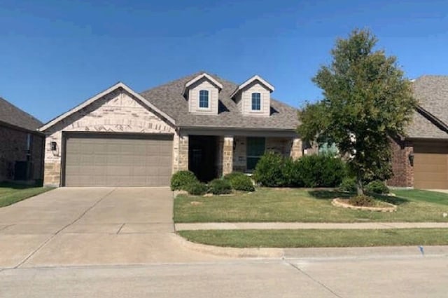 view of front of property featuring a garage and a front lawn