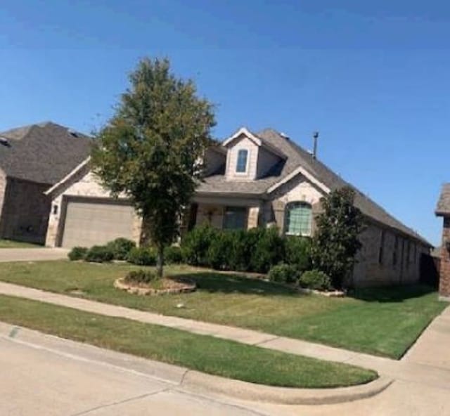 view of front of property with a front yard and a garage