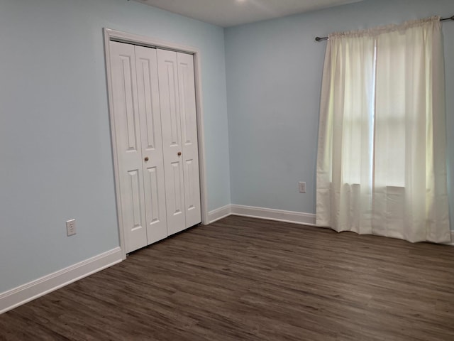 unfurnished bedroom featuring dark hardwood / wood-style floors and a closet