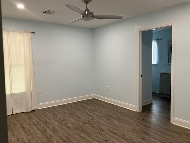 spare room featuring ceiling fan and dark wood-type flooring