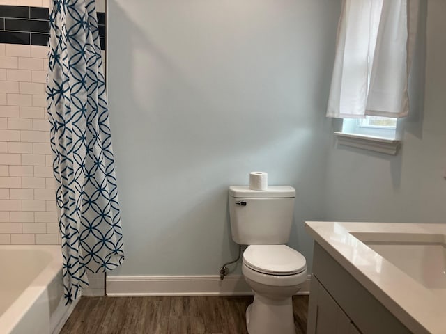 full bathroom with hardwood / wood-style flooring, vanity, toilet, and shower / tub combo