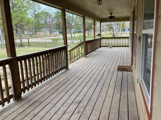 wooden terrace featuring a yard and ceiling fan