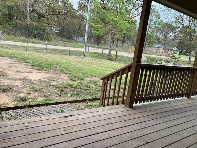 wooden deck featuring a lawn