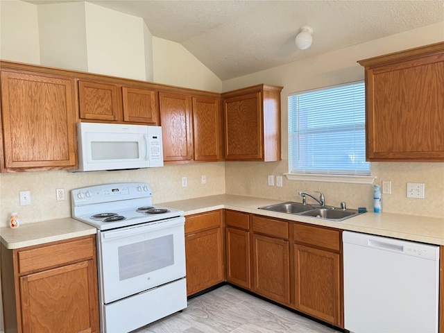 kitchen with a textured ceiling, white appliances, vaulted ceiling, and sink