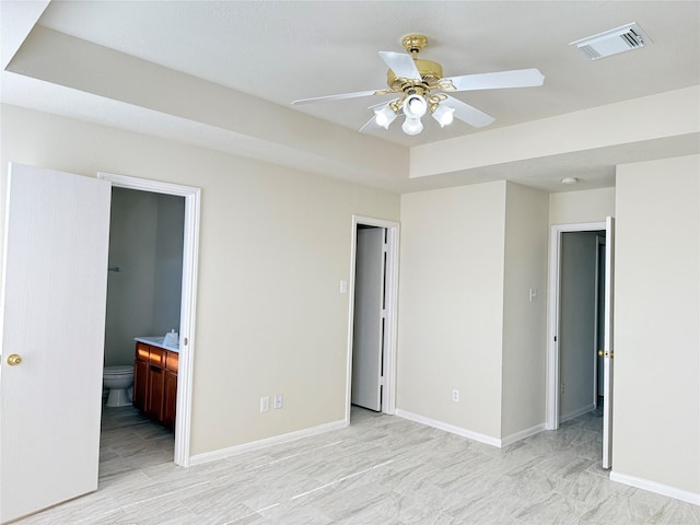 unfurnished bedroom featuring ceiling fan and ensuite bath