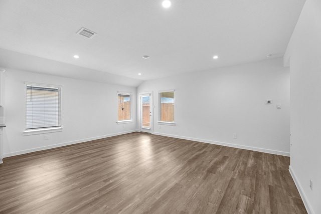 empty room with vaulted ceiling and dark hardwood / wood-style floors