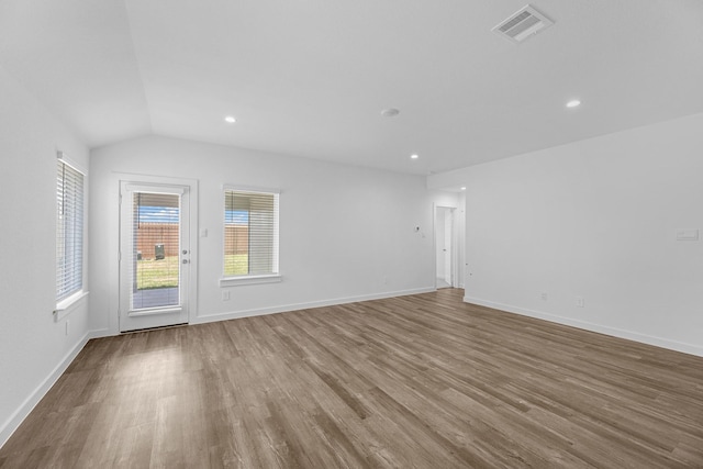 unfurnished room with hardwood / wood-style flooring and vaulted ceiling