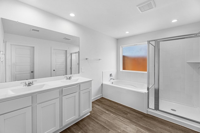 bathroom with plus walk in shower, vanity, and hardwood / wood-style flooring