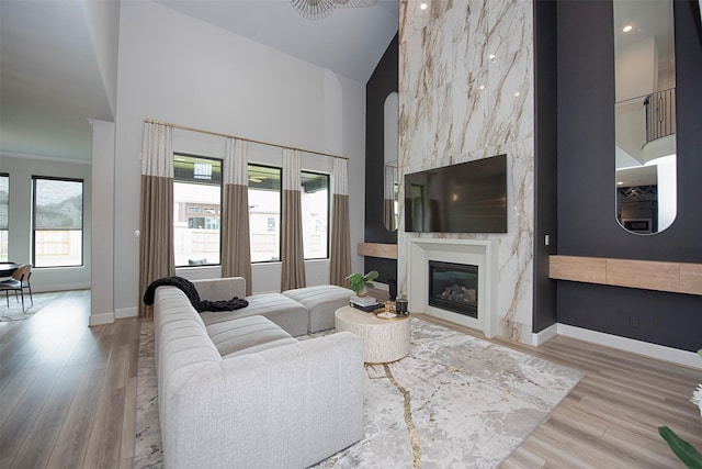 living room featuring a fireplace, high vaulted ceiling, and wood-type flooring