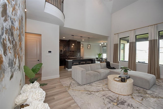 living room with light hardwood / wood-style floors and a high ceiling