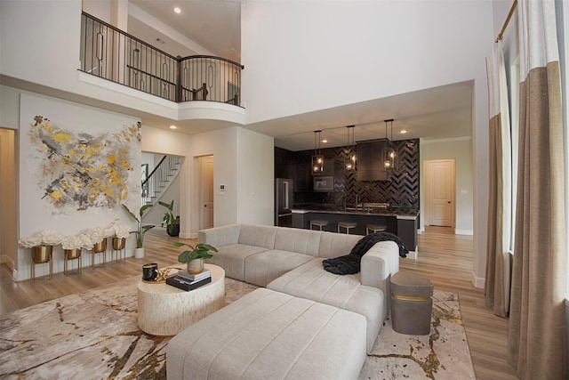 living room featuring a high ceiling and light hardwood / wood-style floors