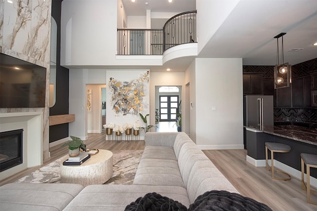 living room featuring a high ceiling and light hardwood / wood-style floors