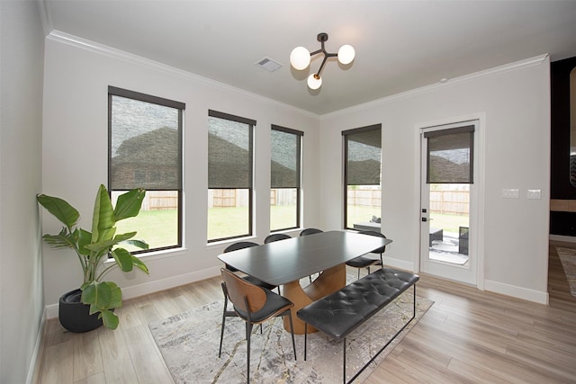 dining area with a chandelier, light hardwood / wood-style flooring, and crown molding