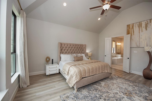 bedroom with ceiling fan, vaulted ceiling, connected bathroom, and light hardwood / wood-style flooring