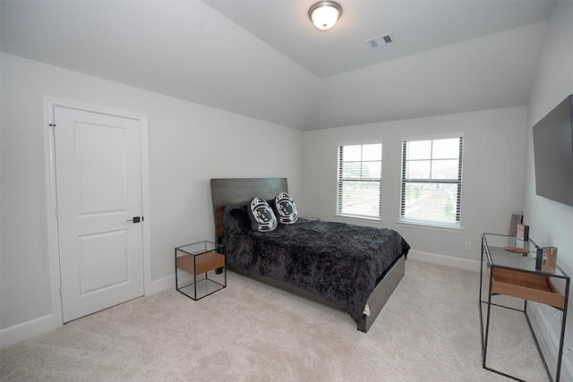 bedroom featuring light colored carpet and lofted ceiling