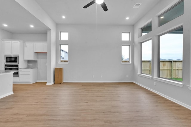 unfurnished living room featuring light hardwood / wood-style flooring and ceiling fan