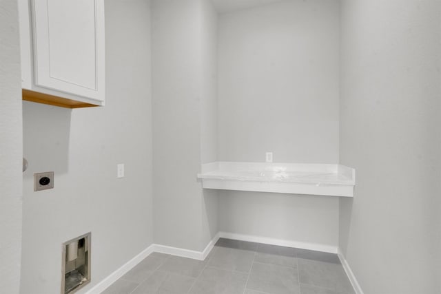 clothes washing area featuring light tile patterned flooring, cabinets, and hookup for an electric dryer