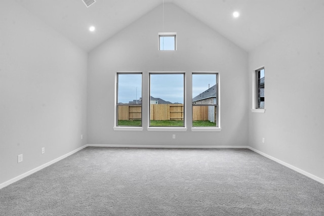 unfurnished room with carpet flooring and high vaulted ceiling