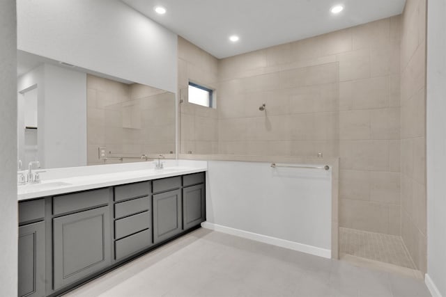 bathroom with tile patterned floors, vanity, and tiled shower