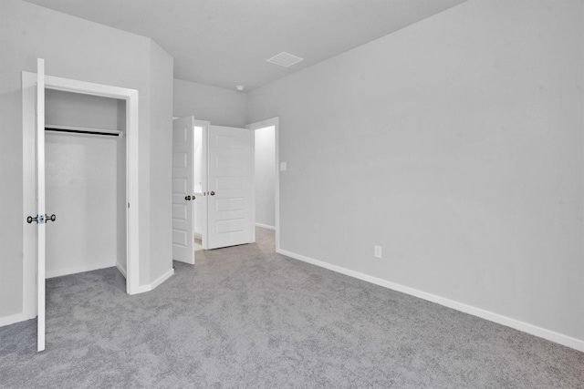 unfurnished bedroom featuring light carpet and a closet