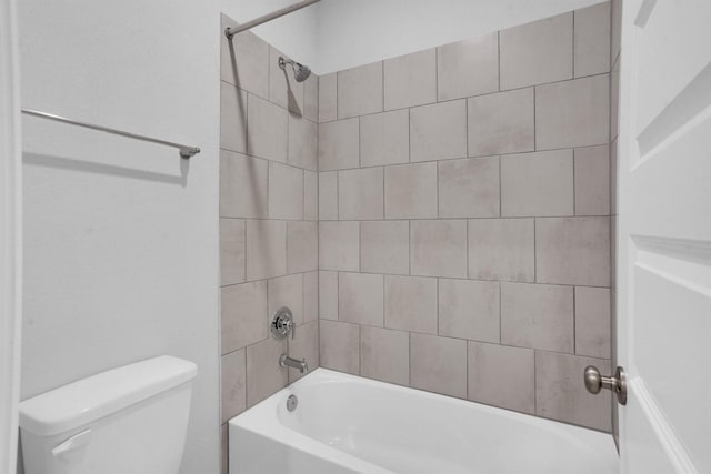 bathroom with tiled shower / bath combo and toilet