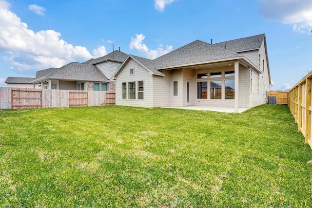 rear view of house with a patio, central AC, and a lawn