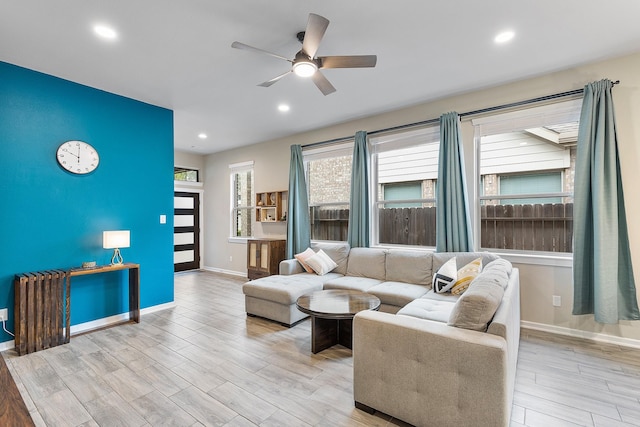 living room with light wood-type flooring, plenty of natural light, and ceiling fan