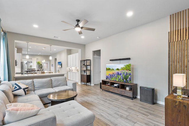 living room featuring ceiling fan and light hardwood / wood-style floors