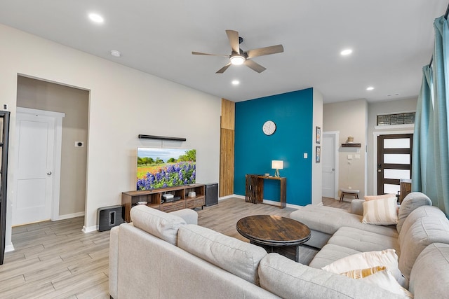 living room with light wood-type flooring, ceiling fan, and a healthy amount of sunlight